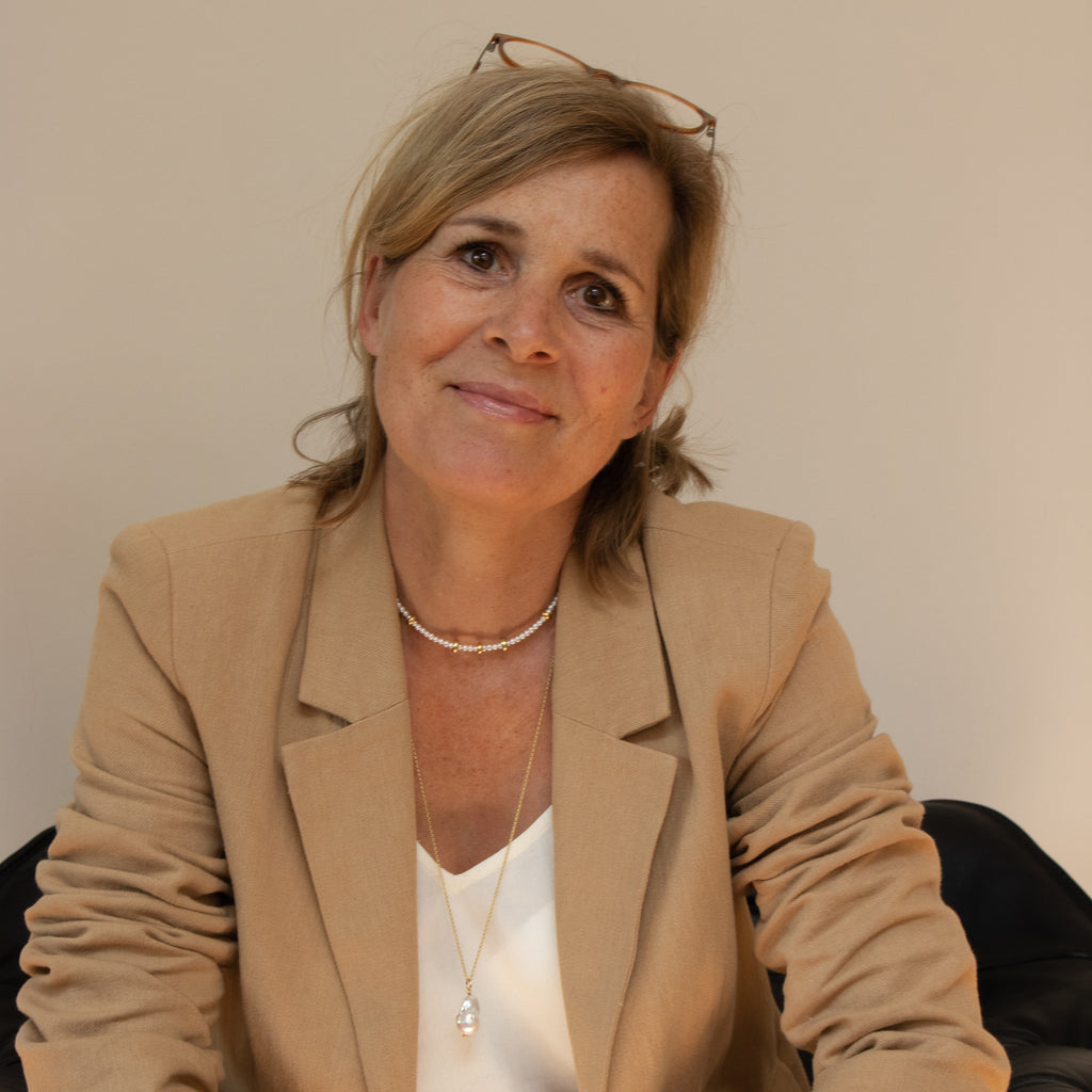 The founder's mother wearing our delicate, timeless Mini Pearl Pea Chain made of real freshwater pearls and gold accents- a family owned business through and through.